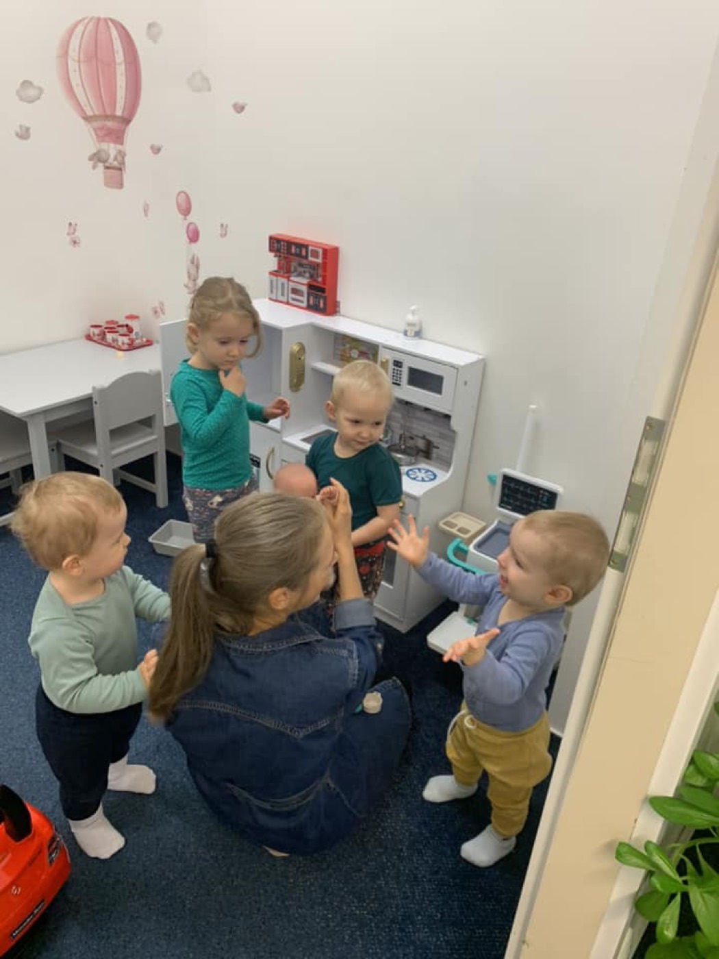 A carer playing with the children in the children's group