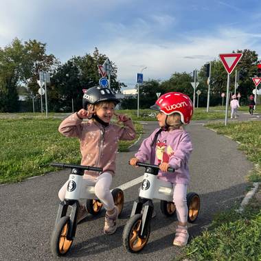 Dvě děti na odrážedlech u dopravních značek